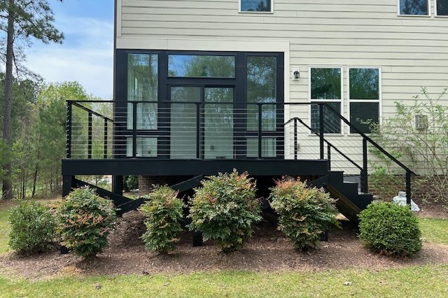 Dark-frame windows and door above a deck