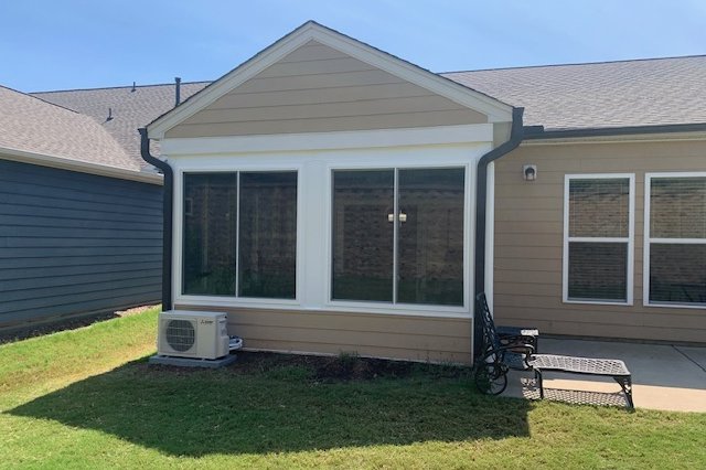 Gable-roof sunroom on a tan-sided home