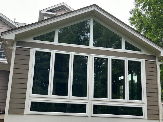 Gable wall of large replacement windows on a gray-sided home