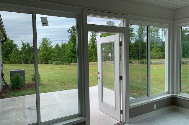 Room with large windows looking out to a backyard