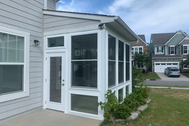 Exterior windows and door with white trim on a gray home
