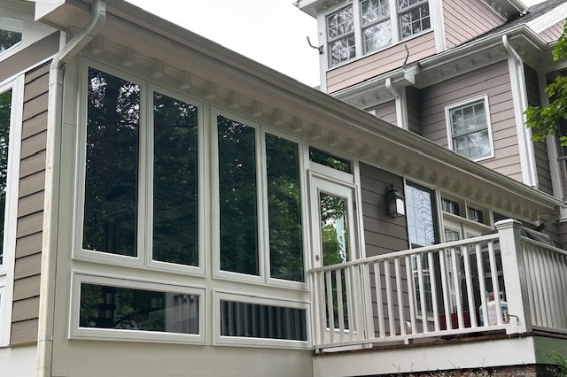 Row of windows with white trim on a tan-sided home